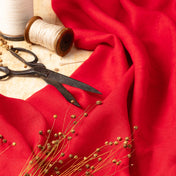 Bright Red linen fabric, ready to cut, with scissors, thread bobbins and flowers