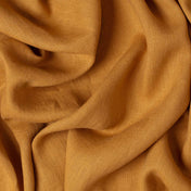 Caramel linen fabric, crumpled to show its natural texture, washed European flax
