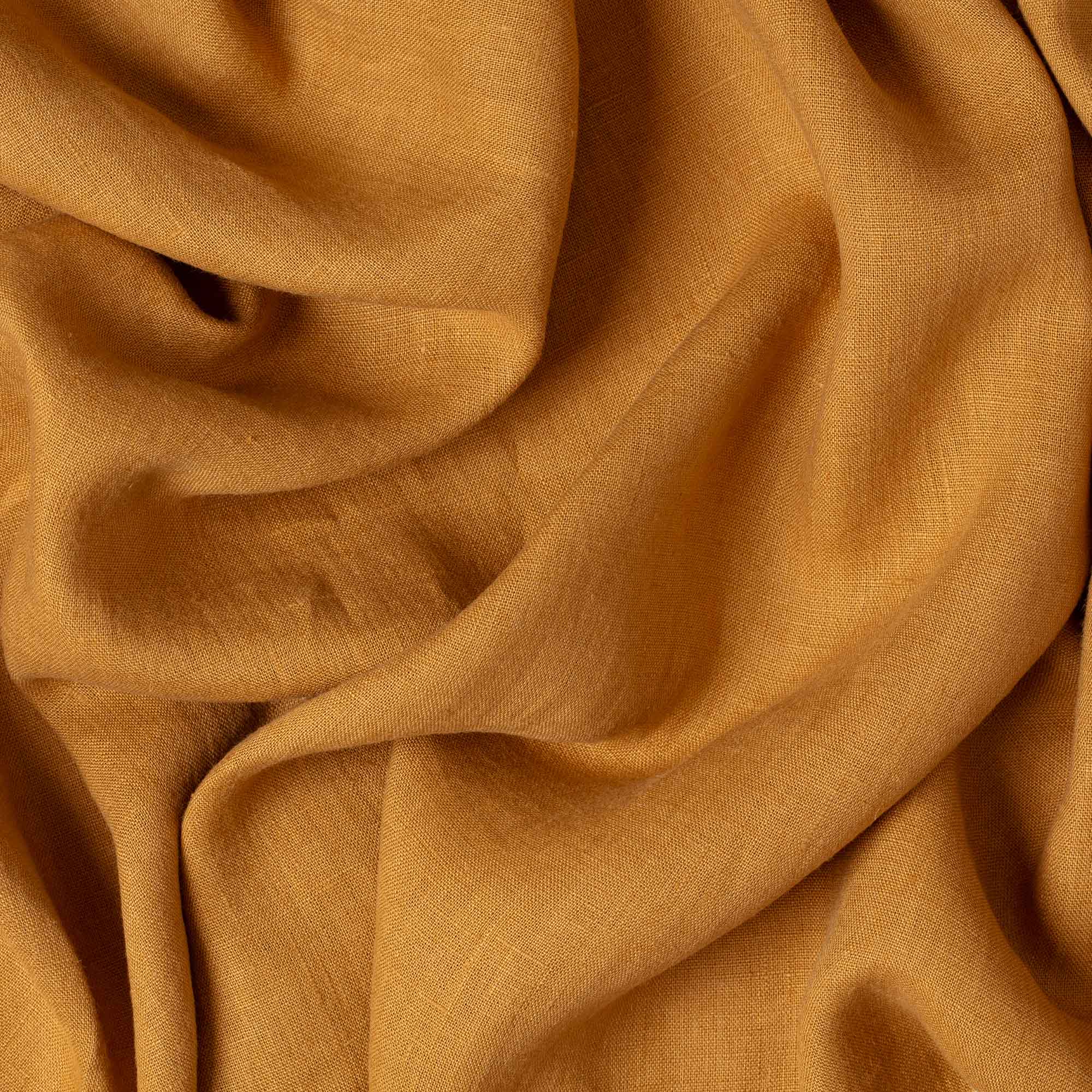 Caramel linen fabric, crumpled to show its natural texture, washed European flax