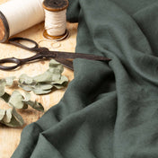 Dark Slate Green linen fabric, ready to cut, with scissors, thread bobbins and dried eucalyptus