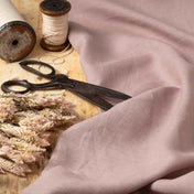 Dusty Lilac linen fabric, ready to cut, with scissors, thread bobbins and flowers
