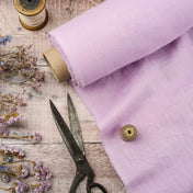 Light Lilac linen fabric, ready to cut, with scissors, thread bobbins and flowers