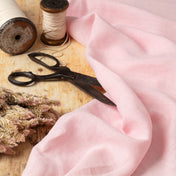 Light Pink linen fabric, ready to cut, with scissors, thread bobbins and flowers