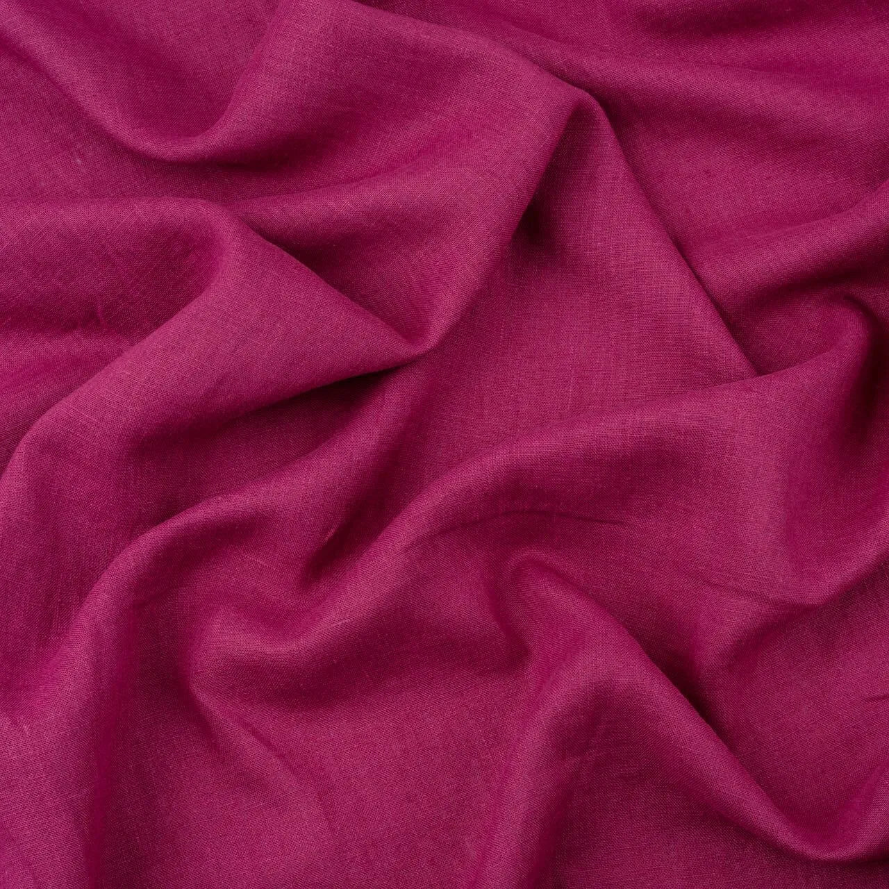 Magenta linen fabric, crumpled to show its natural texture, washed European flax