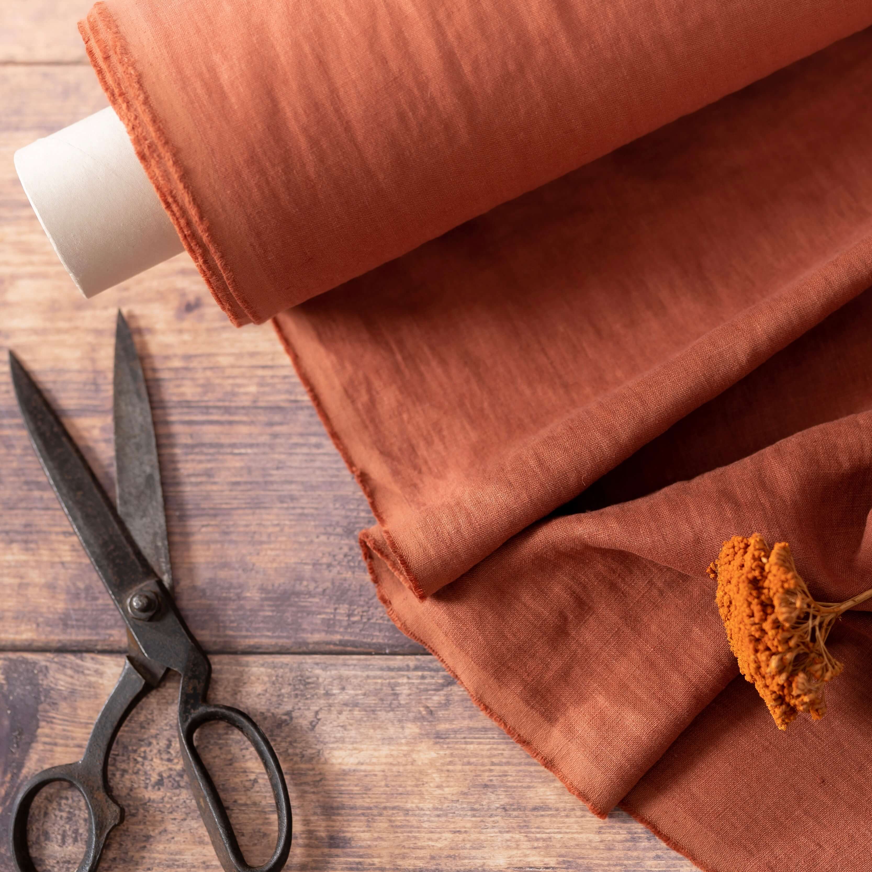 Terracotta linen fabric, ready to cut, with scissors and flowers
