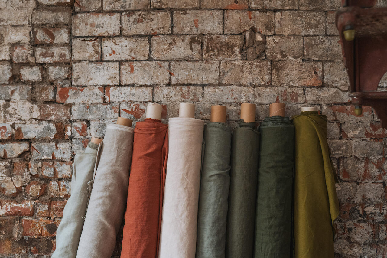 Rolls of linen fabric against brick wall