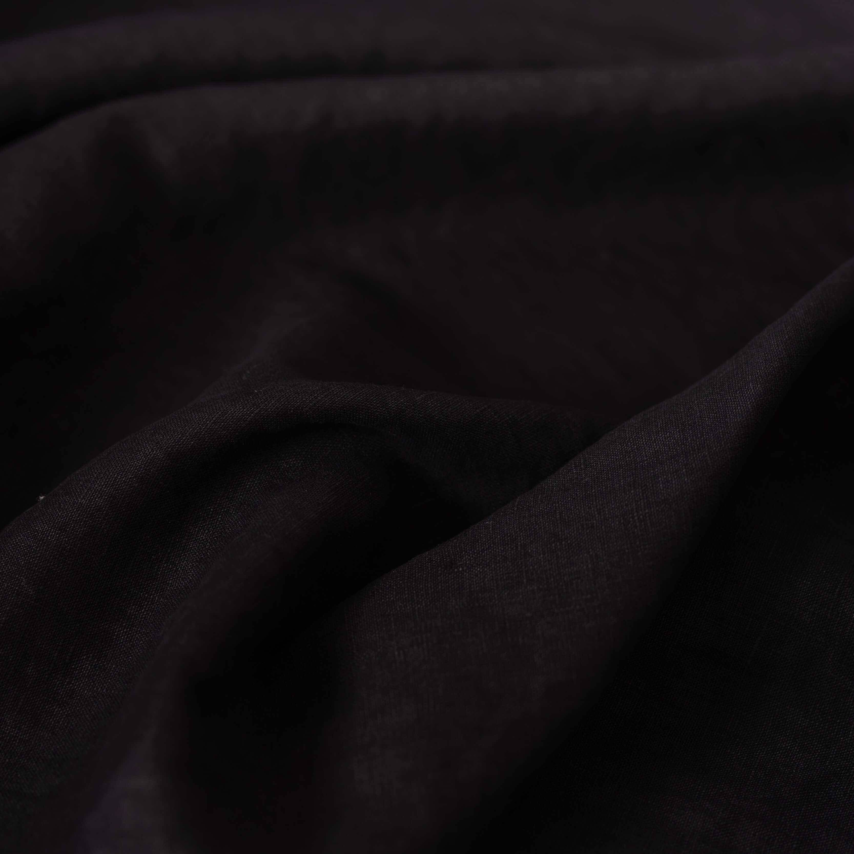 Black linen fabric, crumpled to show its natural texture, washed European flax